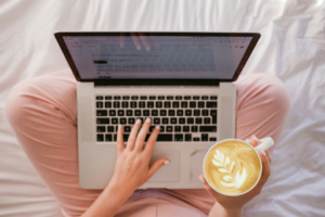 A business professional in an industrial or modern office setting reviewing social media analytics and content strategy on a laptop, representing strategic B2B social media marketing for manufacturing companies building thought leadership and buyer awareness.