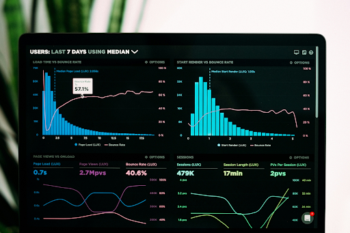 A business professional reviewing performance analytics and data graphs on a laptop screen in a modern office setting, representing how mid-market B2B manufacturers monitor and optimize their visibility inside AI-generated search answers and AI Overviews.